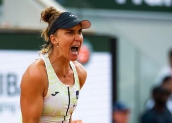 Bia Haddad conquista vitória no Madrid Open após 3 meses 39 Jogadora de tênis gritando com expressão intensa durante partida, usando boné, em quadra com público ao fundo.