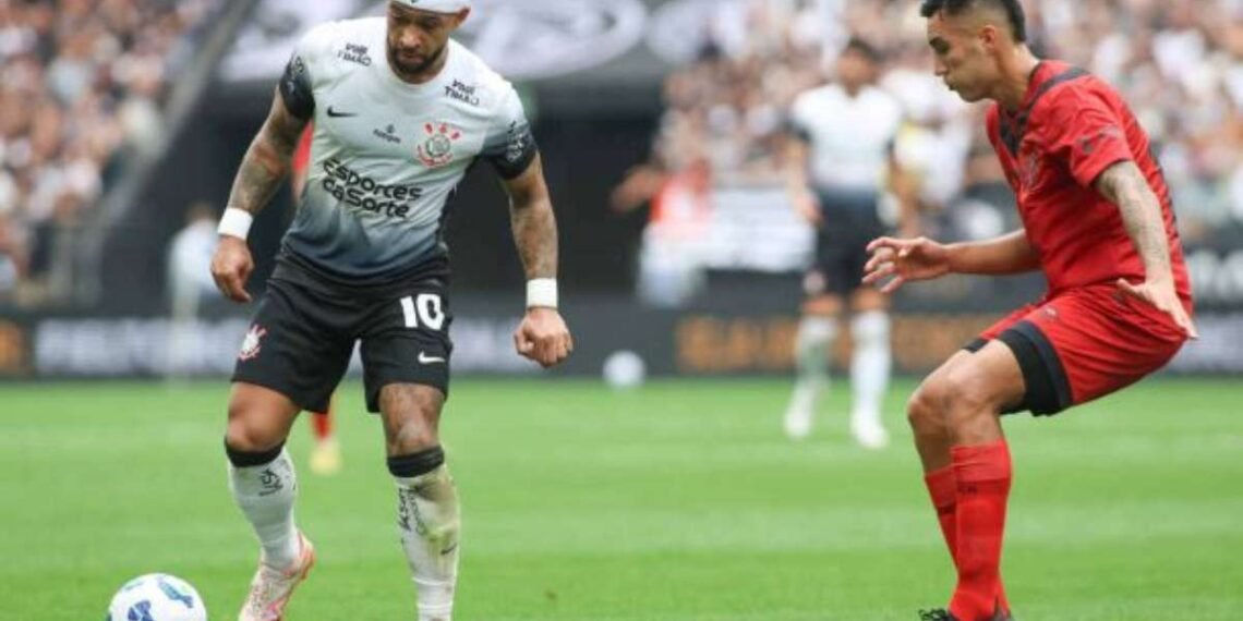 Jogadores driblam em um campo de futebol, um vestindo uniforme preto e branco do Corinthians, o outro em vermelho.