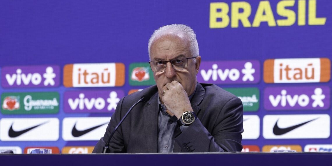 Homem em conferência de imprensa, pensativo, com logotipos ao fundo, destacando marcas e associações ao Brasil.