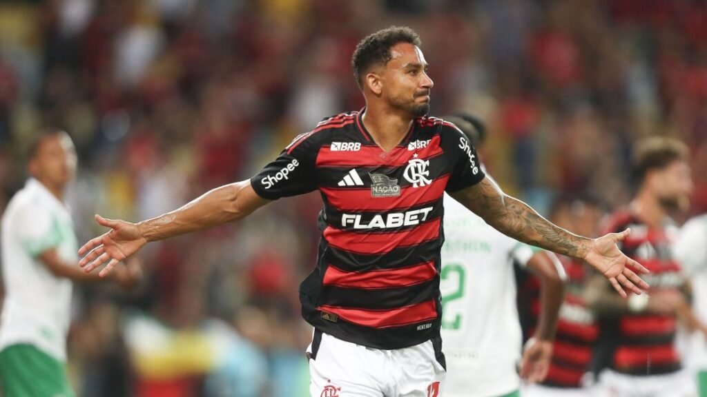 Jogador do Flamengo comemora gol com os braços abertos em partida de futebol vibrante e cheia de emoção no Maracanã.