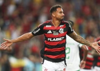 Jogador do Flamengo comemora gol com os braços abertos em partida de futebol vibrante e cheia de emoção no Maracanã.