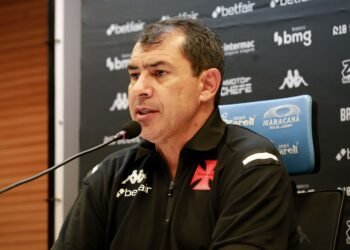 Fábio Carille descarta volta ao Corinthians: '100% comprometido' 36 Homem em coletiva de imprensa, vestindo camisa do Vasco, sentado em frente a microfone. Painel com logotipos ao fundo.