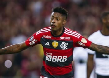 Flamengo comenta indiciamento de Bruno Henrique por fraude 32 Jogador do Flamengo comemora após marcar um gol, vestindo uniforme rubro-negro, em partida de futebol competitivo.