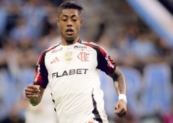 Flamengo pode escalar Bruno Henrique no duelo contra o Juventude 33 Jogador de futebol em ação veste o uniforme do Flamengo, com logotipo do clube visível, em um estádio lotado.