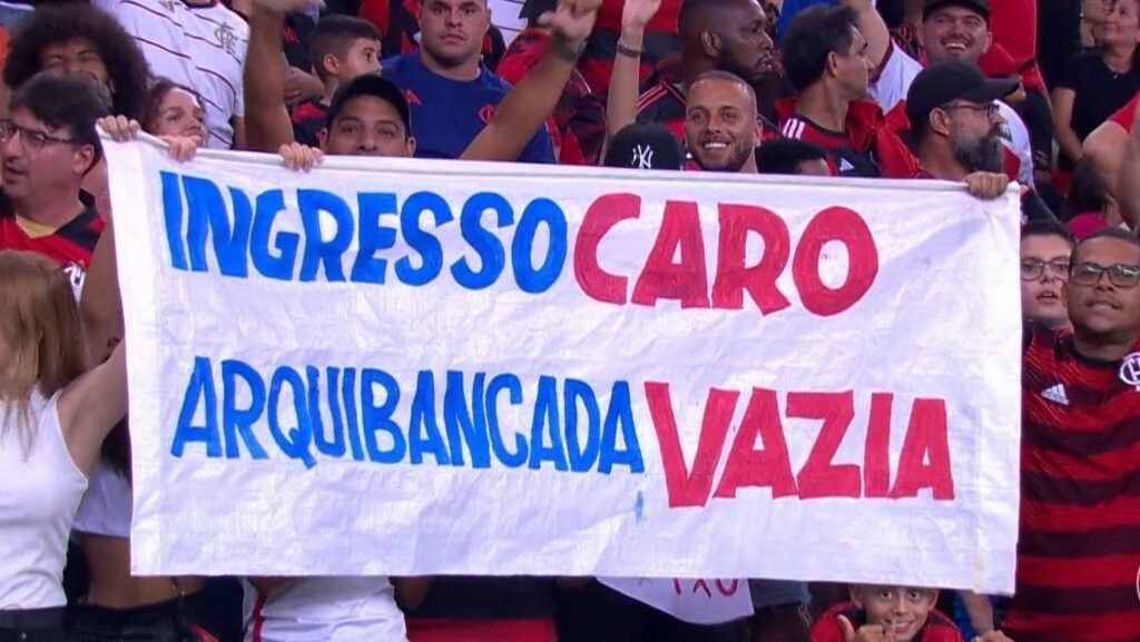 Torcida do Flamengo protesta contra preço de ingressos com faixa: Ingresso caro, arquibancada vazia em jogo no estádio.