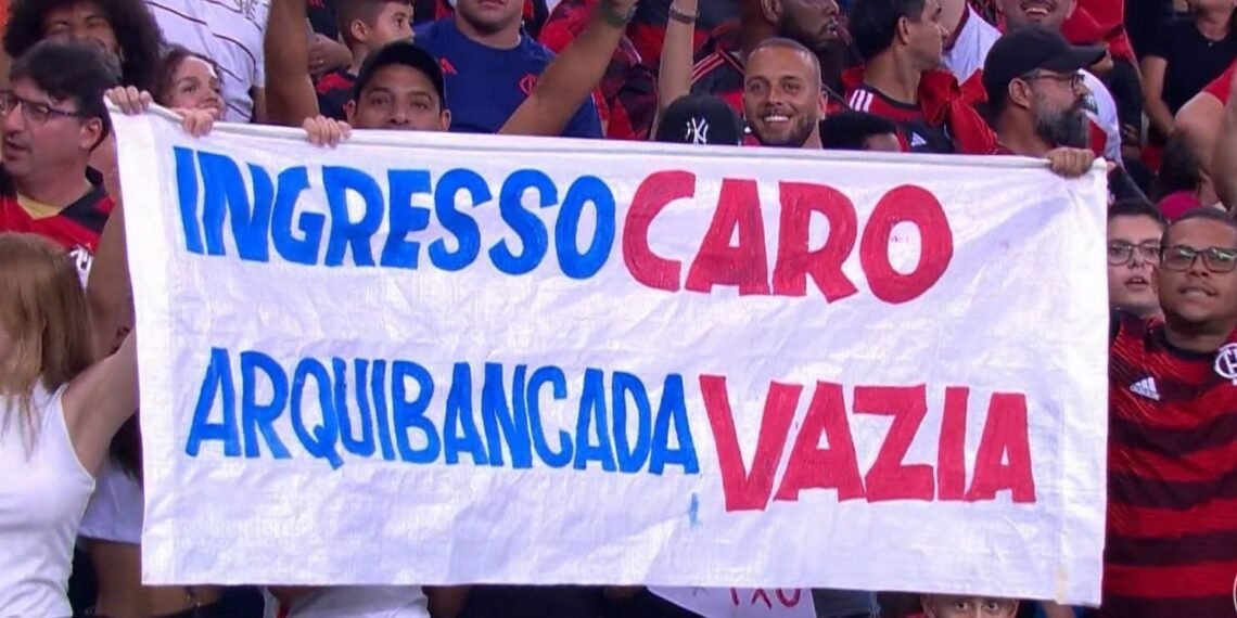 Torcida do Flamengo protesta contra preço de ingressos com faixa: Ingresso caro, arquibancada vazia em jogo no estádio.