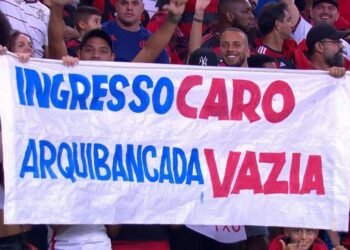 Torcida do Flamengo protesta contra preço de ingressos com faixa: Ingresso caro, arquibancada vazia em jogo no estádio.