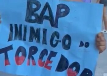 Pessoa segura cartaz azul com a mensagem BAP inimigo do torcedor, expressando descontentamento em protesto público.