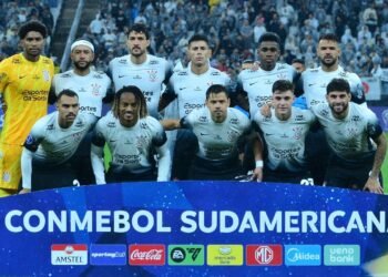Jogadores do Corinthians em pose oficial antes de partida na CONMEBOL Sul-Americana, no estádio, com torcedores ao fundo.