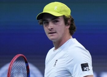 João Fonseca enfrenta ranking baixo e chave difícil em Madri 37 Jogador de tênis jovem com boné verde segura raquete em quadra, transmitindo concentração durante partida intensa.