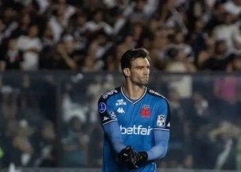 Léo Jardim revela detalhes da renovação com o Vasco 33 Goleiro do Vasco em ação, usando uniforme azul, se prepara no campo, com torcida ao fundo vibrando no estádio.