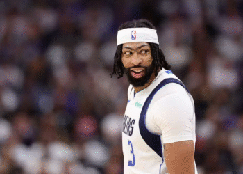 Mavericks eliminam Kings e avançam no play-in da NBA 2023 35 Jogador de basquete sorri na quadra com uniforme branco e faixa na cabeça, durante partida intensa de basquete.