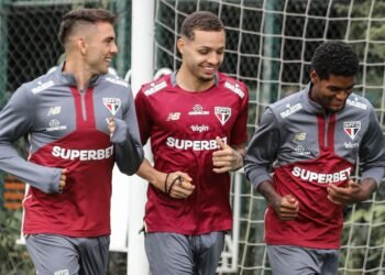São Paulo tem vantagem histórica sobre clubes paraguaios na Liberta 39 Jogadores do São Paulo FC sorridentes durante treino, vestindo uniforme do time, em campo com rede de fundo.