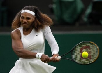Serena Williams: 'Sinner teria 20 anos de pena por doping' 32 Tenista em ação durante partida, batendo forehand de uniforme branco, com expressão concentrada e raquete em movimento.