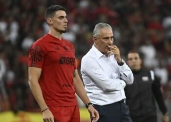 Tite pronto para novo desafio: "Malas prontas", diz nora 36 Técnico e jogador do Flamengo observam o jogo com concentração no estádio cheio, durante uma partida importante do campeonato.