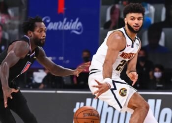 Top Viradas Históricas dos Playoffs da NBA: Emocionantes Reviravoltas 34 Jogador de basquete em ação desviando de marcador em partida, vestindo uniformes das equipes, com foco na bola.