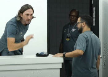 Zubeldía responde a jornalista após empate struggle do São Paulo 31 Homem gesticula durante conversa animada com dois funcionários em uma sala, destacando interação intensa no ambiente de trabalho.