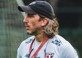 Zubeldía se irrita com repórter após empate São Paulo x Botafogo 32 Homem com boné preto e camisa do São Paulo FC no campo, aparentando concentração. Fundo desfocado de rede de futebol.