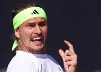 Zverev e Shelton duelam na final do ATP de Munique 2023 39 Jogador de tênis usando faixa verde neon enquanto se prepara para um saque, transmitindo determinação e foco.